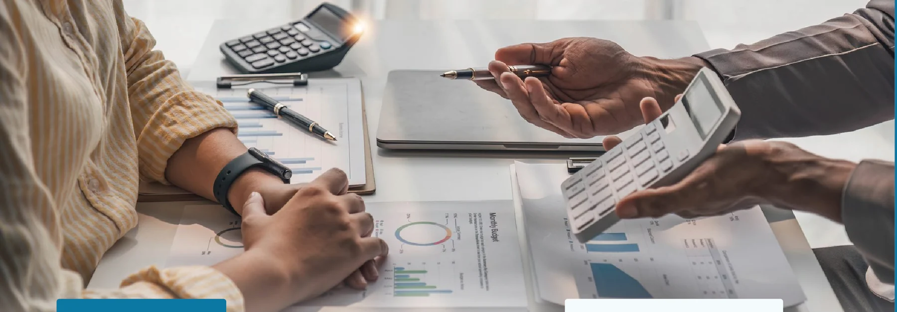 Accountant and client reviewing printed financial reports with a calculator