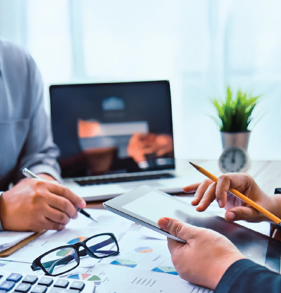 Laptop and tablet on a desk during a financial review meeting