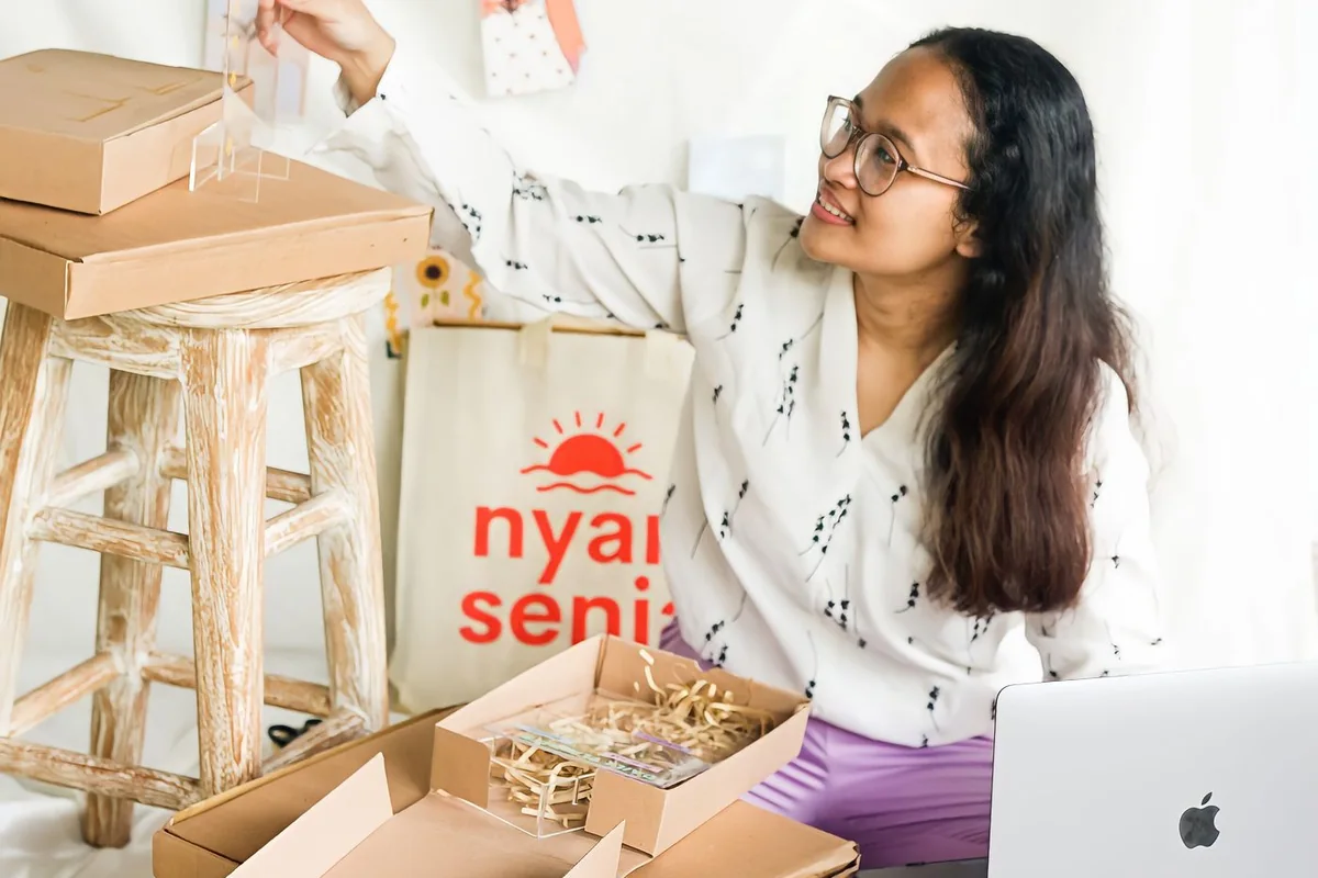 Small business owner packing customer orders into boxes